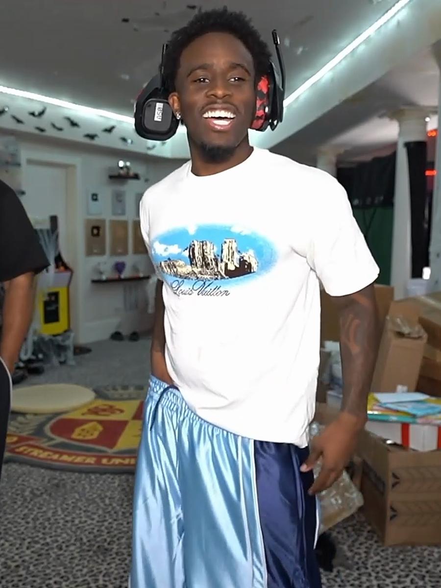 Kai Cenat smiling in the Obsidian Blue Worldwide Polyester Jorts